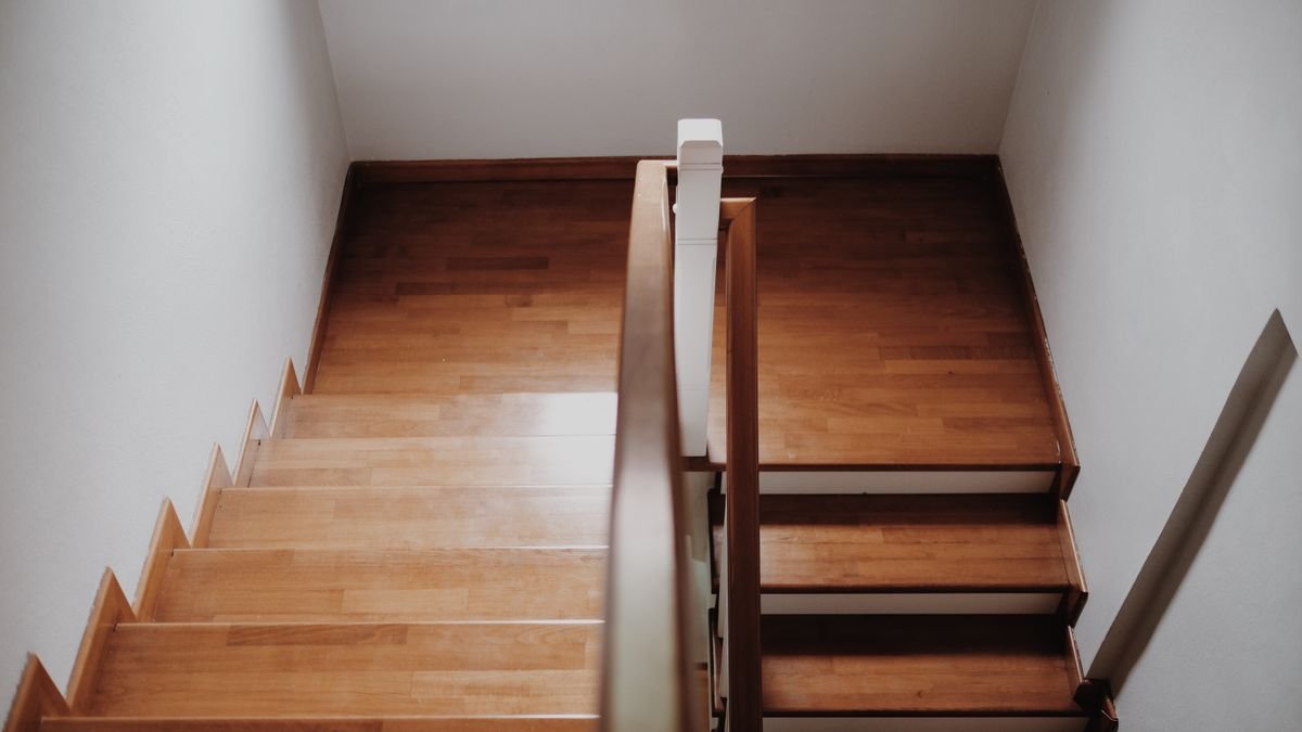 Top view of a wooden staircase in a minimalist interior, showcasing clean lines and elegant design.