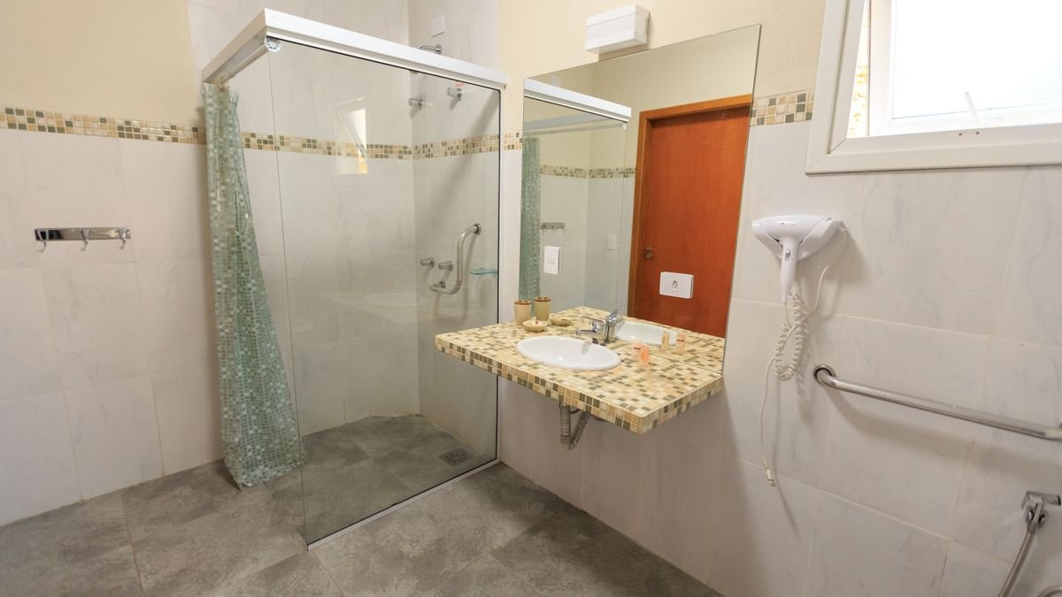 Spacious and accessible bathroom featuring a large glass shower, modern sink, and stylish decor.