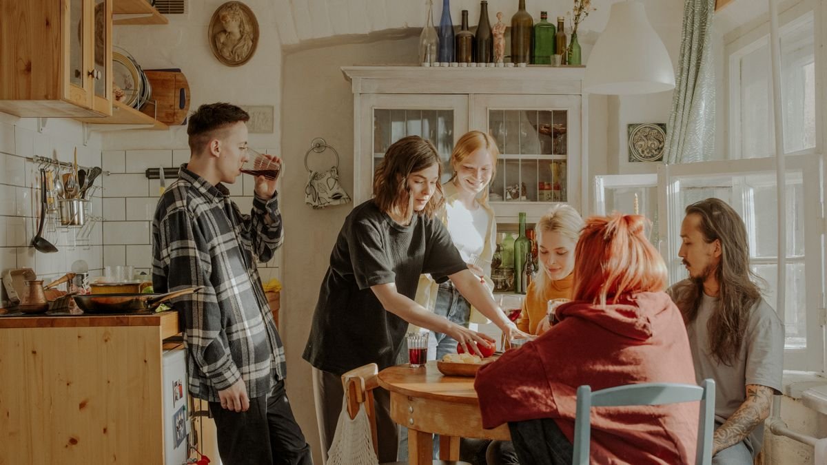Friends enjoy a relaxed moment together in a sunny kitchen, reflecting a lifestyle of camaraderie and warmth.